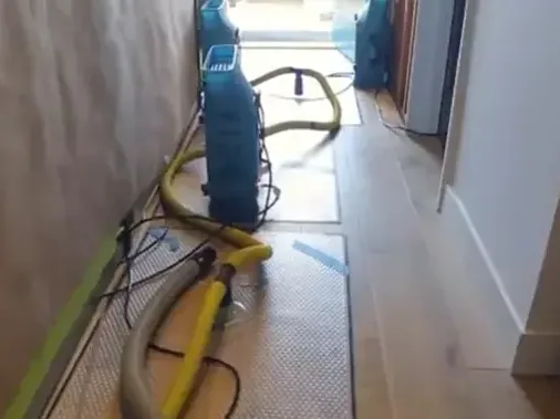 Dehumidifier and hoses set up in a hallway during drying