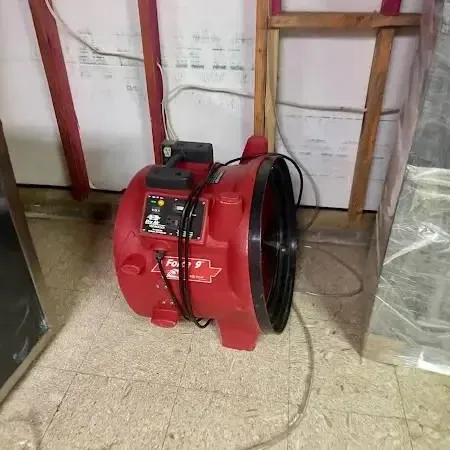 Plastic sheeting and a red air mover drying an opened wall for a Diamond Bar home